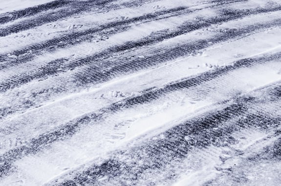 Image of snow on driveway with tire marks